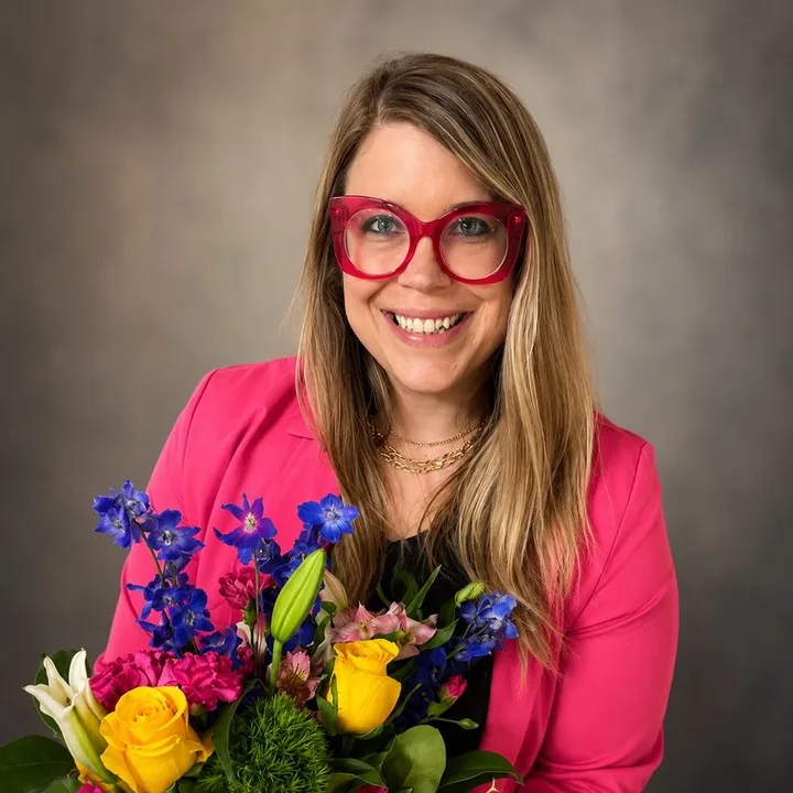 Mariah Gibson, smiling and holding a bright bouquet of flowers